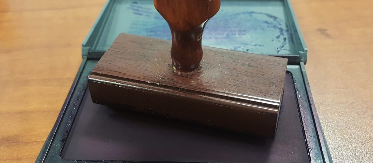 tampon de notaire en bois posé sur son ancrier