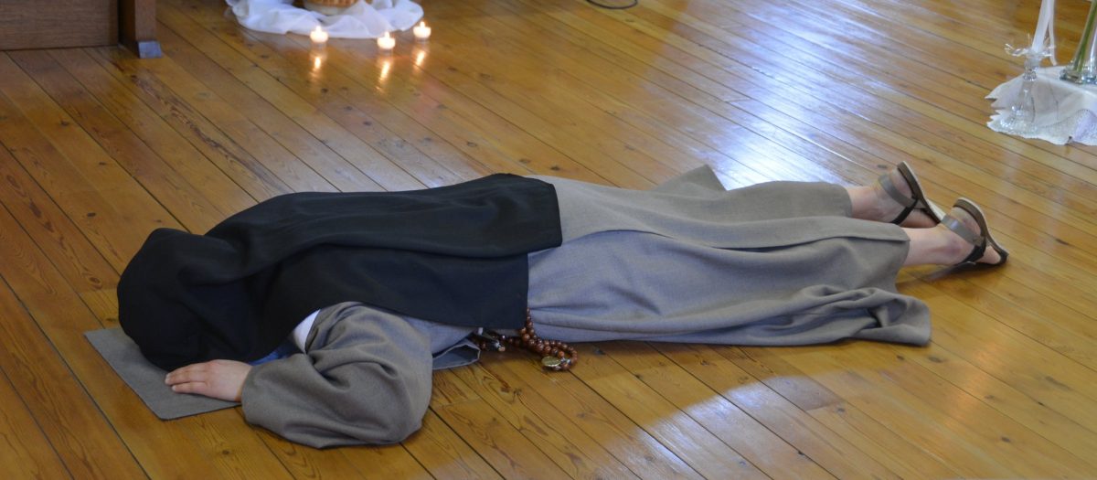 religieuse allongée face contre terre dans une chapelle pour prononcer ses voeux perpétuels
